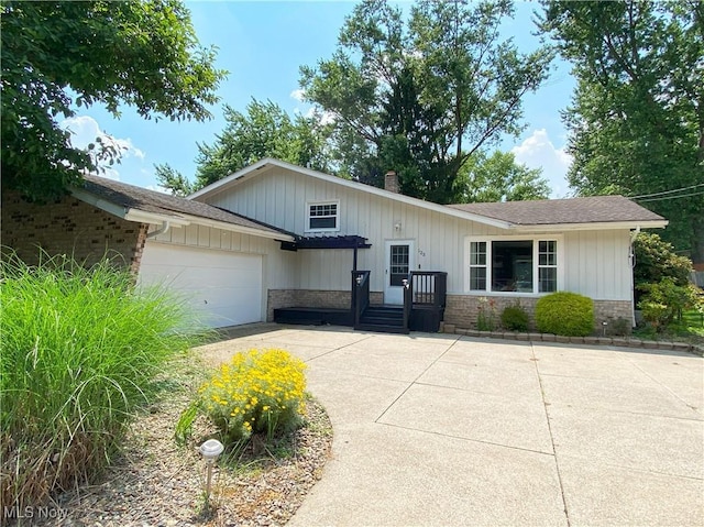 123 Prentiss St, Munroe Falls, OH 44262 - view of front of property with a garage, concrete driveway, a chimney, and a shingled roof