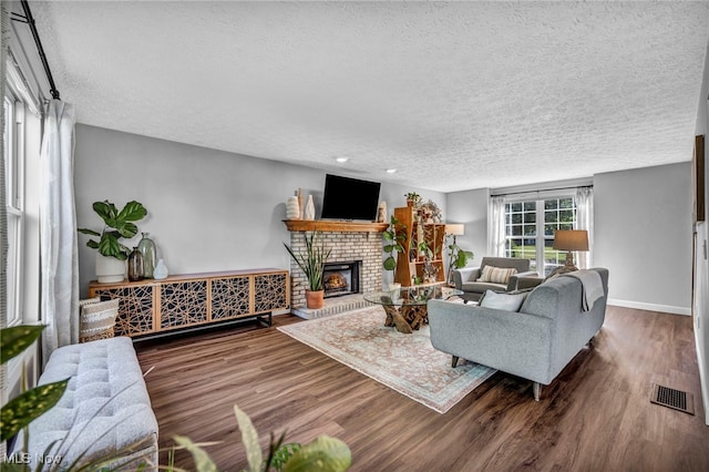 567 Westminster Cir, Akron, OH 44319 - living room featuring a textured ceiling, wood finished floors, and a brick fireplace
