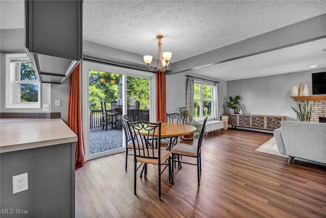 567 Westminster Cir, Akron, OH 44319 - dining room featuring wood finished floors, a textured ceiling, a chandelier, and healthy amount of natural light