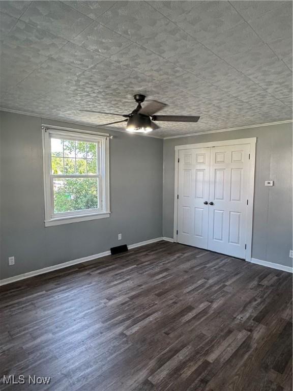 358 N 8th St, Coshocton, OH 43812 - unfurnished bedroom featuring dark wood-type flooring, ornamental molding, ceiling fan, and a closet