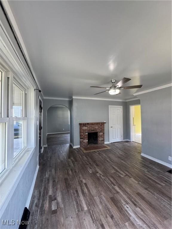 358 N 8th St, Coshocton, OH 43812 - unfurnished living room with a ceiling fan, dark wood-style flooring, a brick fireplace, crown molding, and arched walkways