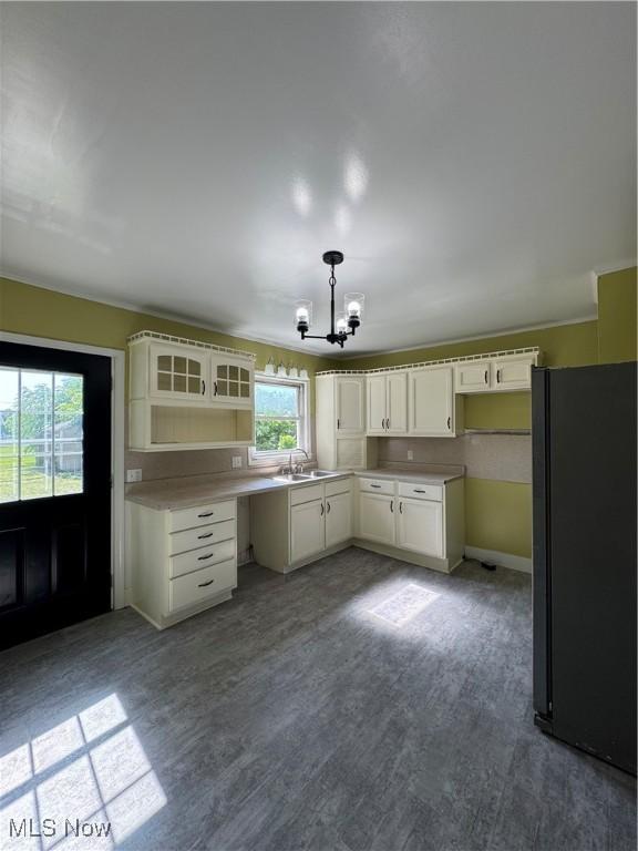 358 N 8th St, Coshocton, OH 43812 - kitchen featuring freestanding refrigerator, a chandelier, glass insert cabinets, dark wood-style floors, and pendant lighting
