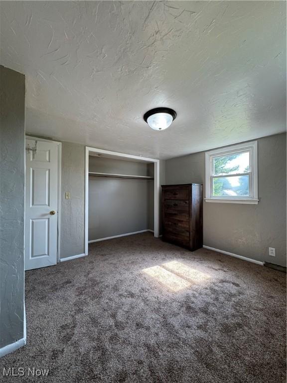 358 N 8th St, Coshocton, OH 43812 - unfurnished bedroom with carpet floors, a textured ceiling, and a closet