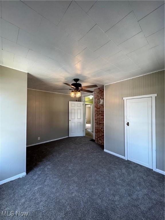 358 N 8th St, Coshocton, OH 43812 - unfurnished bedroom featuring carpet, a ceiling fan, and wood walls