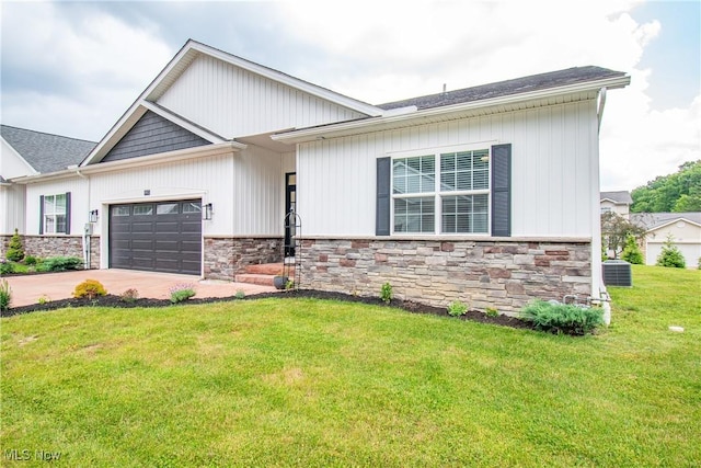 993 Pin Oaks Dr, Broadview Heights, OH 44147 - view of front of house with stone siding, an attached garage, driveway, and a front yard