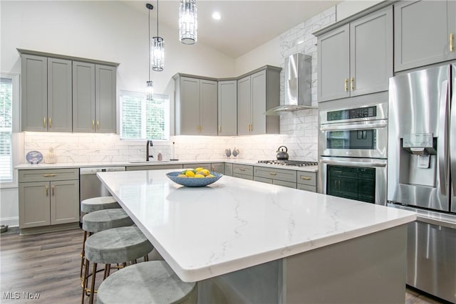 993 Pin Oaks Dr, Broadview Heights, OH 44147 - kitchen with stainless steel appliances, gray cabinetry, wall chimney range hood, light stone countertops, and backsplash