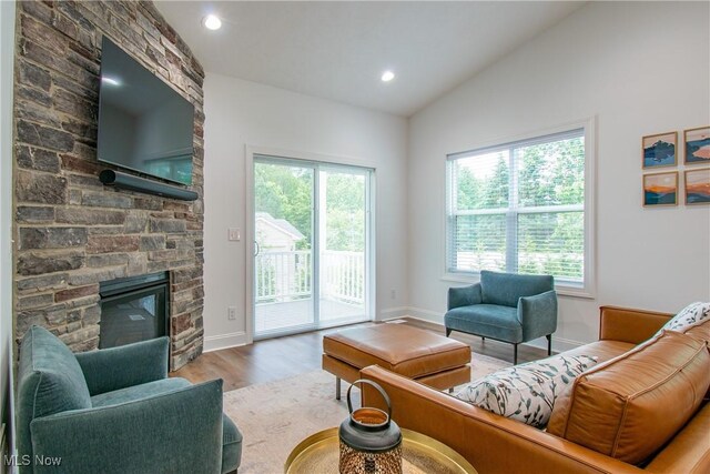 993 Pin Oaks Dr, Broadview Heights, OH 44147 - living room featuring wood finished floors, vaulted ceiling, a stone fireplace, and recessed lighting