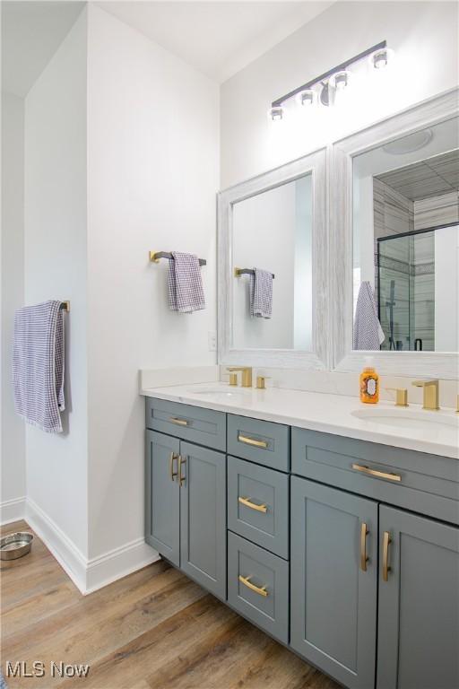 993 Pin Oaks Dr, Broadview Heights, OH 44147 - bathroom with double vanity, a stall shower, and wood finished floors
