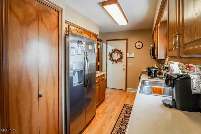 1769 Clearbrook Rd NW, Massillon, OH 44646 - kitchen featuring stainless steel appliances, brown cabinetry, light countertops, and light wood-type flooring