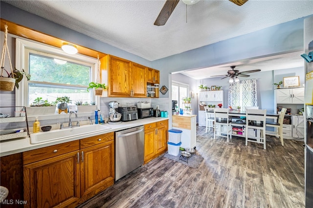 6086 N Wright St, Kingsville, OH 44048 - kitchen with stainless steel dishwasher, a ceiling fan, dark wood finished floors, brown cabinetry, and a textured ceiling