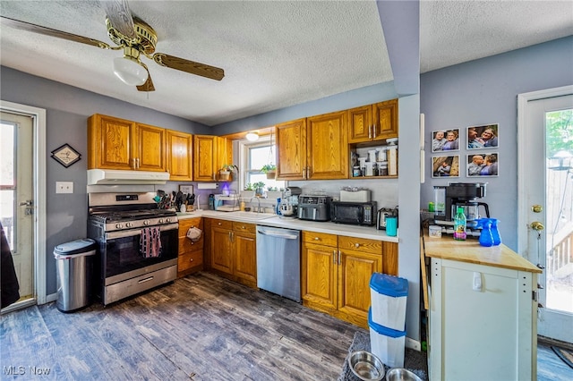 6086 N Wright St, Kingsville, OH 44048 - kitchen with stainless steel appliances, under cabinet range hood, a textured ceiling, dark wood-style floors, and light countertops