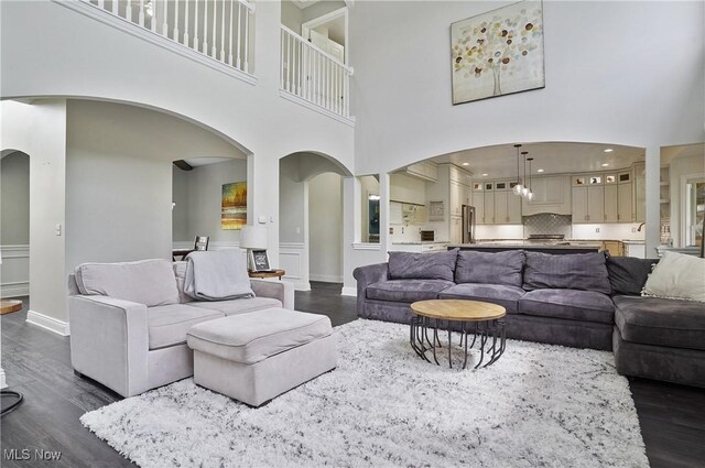 7305 Alexander Rd, Concord, OH 44077 - living room with arched walkways, dark wood-type flooring, and a high ceiling