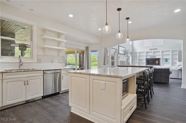 7305 Alexander Rd, Concord, OH 44077 - kitchen with stainless steel dishwasher, dark wood-style floors, a center island, light stone counters, and recessed lighting