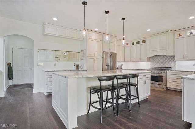 7305 Alexander Rd, Concord, OH 44077 - kitchen featuring stainless steel appliances, arched walkways, dark wood-type flooring, white cabinetry, and recessed lighting