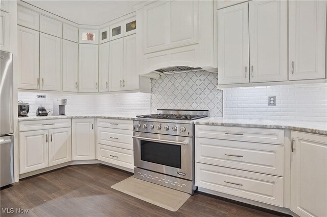 7305 Alexander Rd, Concord, OH 44077 - kitchen featuring stainless steel appliances, white cabinetry, dark wood-type flooring, tasteful backsplash, and glass insert cabinets