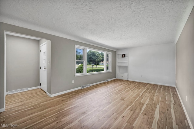 4928 Lane Rd, Perry, OH 44081 - spare room with light wood finished floors, a textured ceiling, and built in shelves