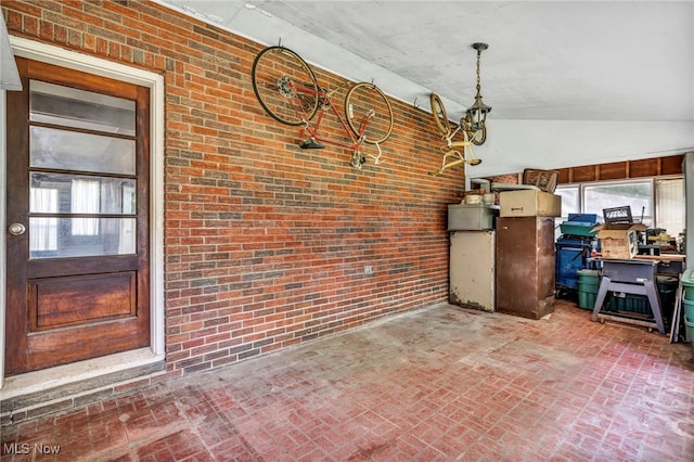4928 Lane Rd, Perry, OH 44081 - unfurnished dining area featuring brick patterned floors, brick wall, and lofted ceiling