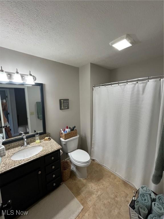 1315 Cascade Cir E, Canton, OH 44708 - full bathroom with vanity, a textured ceiling, tile patterned floors, and a shower with shower curtain