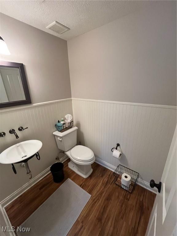 1315 Cascade Cir E, Canton, OH 44708 - half bath with a wainscoted wall, wood finished floors, and a textured ceiling