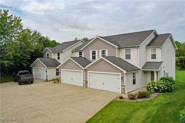 1315 Cascade Cir E, Canton, OH 44708 - view of front of house with driveway, a front yard, roof with shingles, stone siding, and an attached garage