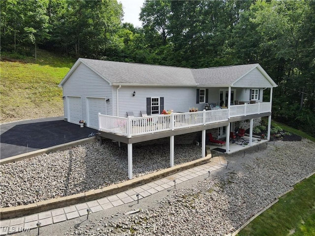 47688 Tomahawk Dr, Negley, OH 44441 - single story home with a wooden deck, roof with shingles, a garage, and a patio