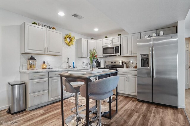 47688 Tomahawk Dr, Negley, OH 44441 - kitchen with stainless steel appliances, light wood-type flooring, decorative backsplash, light countertops, and recessed lighting