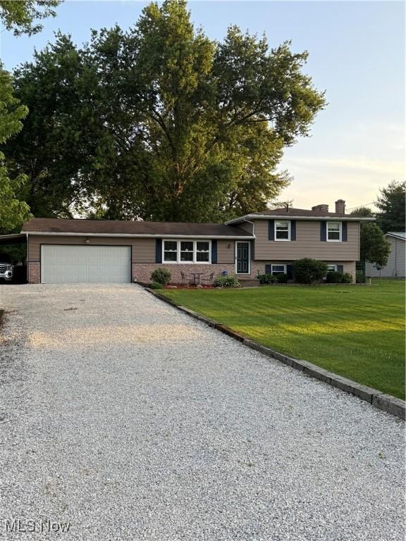 11778 Sharp Dr, Doylestown, OH 44230 - tri-level home featuring gravel driveway, an attached garage, a front yard, and a carport