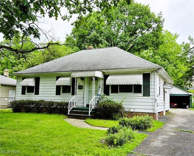 16241 Glenburn Ave, Maple Heights, OH 44128 - view of front of home featuring a front lawn, roof with shingles, a chimney, and an outdoor structure