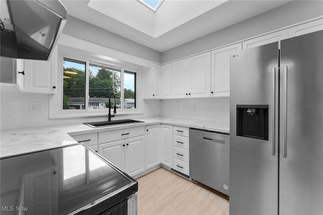 70 Maple St, Canfield, OH 44406 - kitchen with appliances with stainless steel finishes, extractor fan, white cabinets, tasteful backsplash, and light stone counters