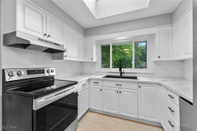 70 Maple St, Canfield, OH 44406 - kitchen with stainless steel appliances, under cabinet range hood, white cabinets, and light stone countertops