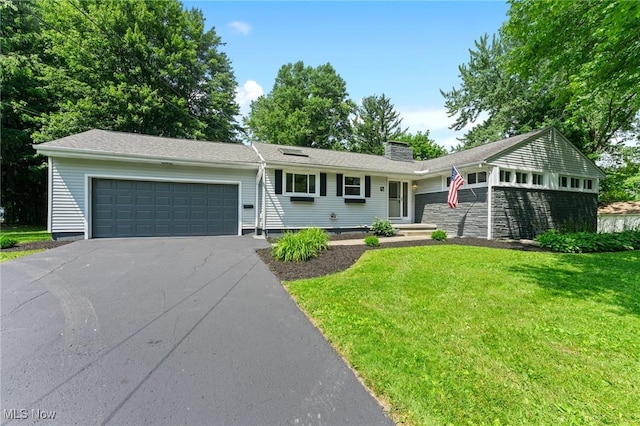 70 Maple St, Canfield, OH 44406 - single story home featuring a front lawn, a chimney, an attached garage, and driveway