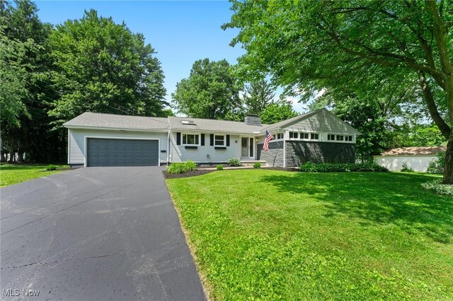 70 Maple St, Canfield, OH 44406 - ranch-style house featuring driveway, an attached garage, a front lawn, and a chimney