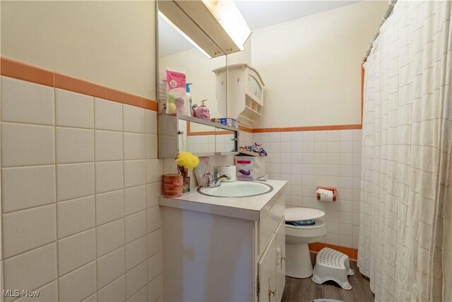 1715 High St, Louisville, OH 44641 - bathroom with tile walls, vanity, a shower with curtain, and a wainscoted wall