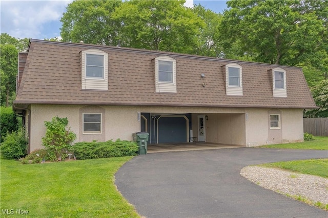 1715 High St, Louisville, OH 44641 - front of property with stucco siding, a shingled roof, mansard roof, and asphalt driveway