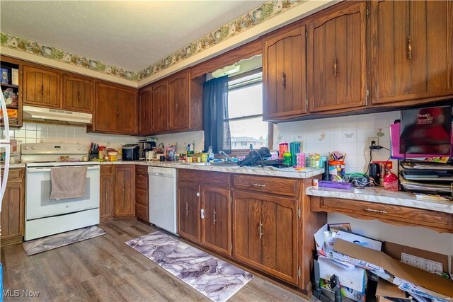 1715 High St, Louisville, OH 44641 - kitchen featuring white appliances, under cabinet range hood, light countertops, backsplash, and a textured ceiling