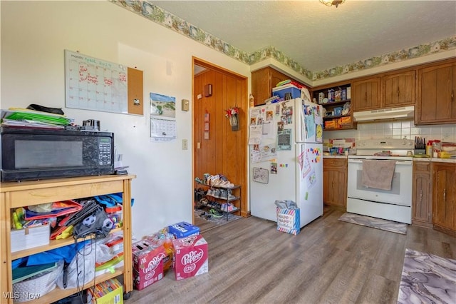 1715 High St, Louisville, OH 44641 - kitchen featuring white appliances, under cabinet range hood, wood finished floors, brown cabinets, and light countertops