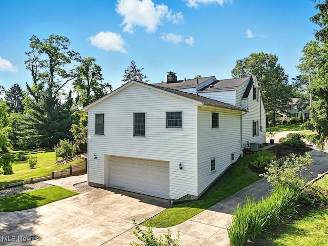 5105 E Sprague Rd, Independence, OH 44131 - view of side of property featuring driveway, an attached garage, a chimney, a shingled roof, and a lawn