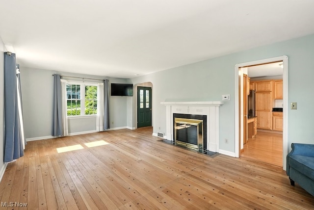 5105 E Sprague Rd, Independence, OH 44131 - unfurnished living room featuring arched walkways, light wood-style floors, and a fireplace with flush hearth