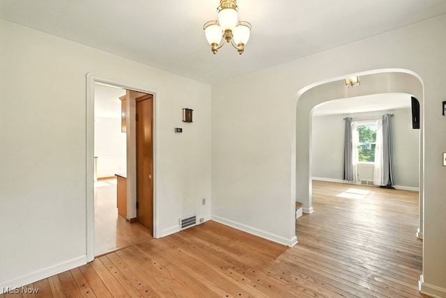 5105 E Sprague Rd, Independence, OH 44131 - unfurnished room featuring arched walkways, a chandelier, and light wood-type flooring