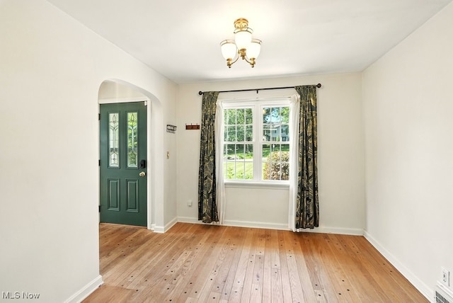 5105 E Sprague Rd, Independence, OH 44131 - entryway with arched walkways, light wood finished floors, and a chandelier