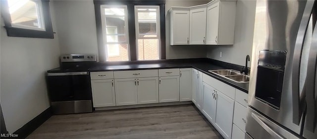 1134 E Main St, Coshocton, OH 43812 - kitchen featuring stainless steel appliances, dark countertops, white cabinetry, and wood finished floors