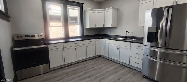 1134 E Main St, Coshocton, OH 43812 - kitchen with stainless steel appliances, dark countertops, white cabinets, and light wood finished floors