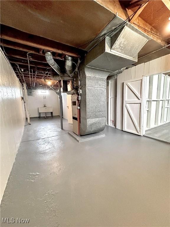 unfinished below grade area with heating unit and a sink
