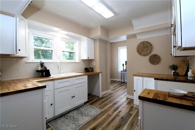 1120 Delia Ave, Akron, OH 44320 - kitchen featuring wood counters, decorative backsplash, white cabinetry, and light wood-style flooring