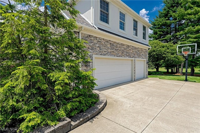 4837 Arbour Green Dr, Bath, OH 44333 - view of side of property with stone siding, a garage, and stucco siding