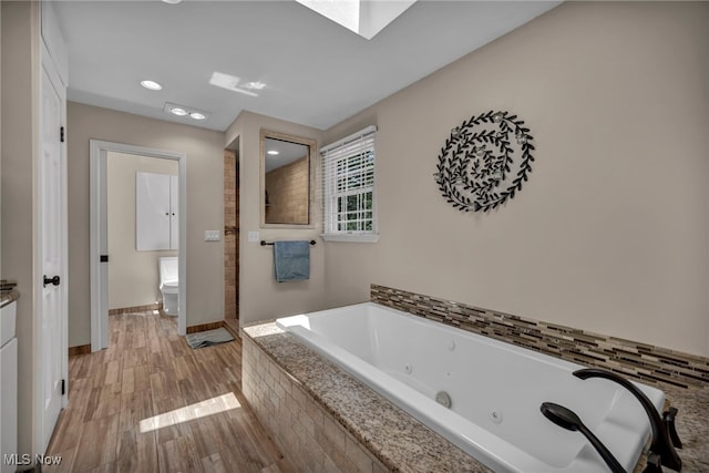 561 Willard Rd, Aurora, OH 44202 - bathroom with a jetted tub, wood finished floors, and recessed lighting