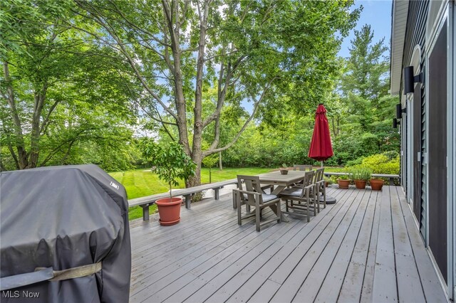 561 Willard Rd, Aurora, OH 44202 - wooden terrace with a grill, outdoor dining space, and view of wooded area