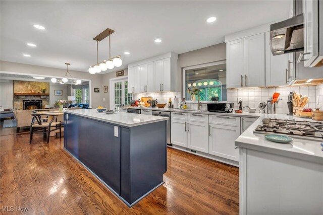 561 Willard Rd, Aurora, OH 44202 - kitchen with appliances with stainless steel finishes, a kitchen island, backsplash, white cabinets, and recessed lighting