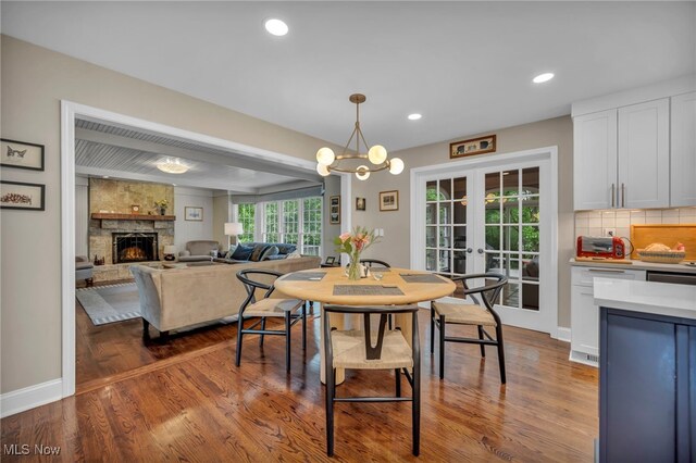 561 Willard Rd, Aurora, OH 44202 - dining area with a fireplace, french doors, dark wood-type flooring, recessed lighting, and a chandelier