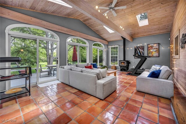 561 Willard Rd, Aurora, OH 44202 - tiled living room with a skylight, a wood stove, ceiling fan, and wooden ceiling